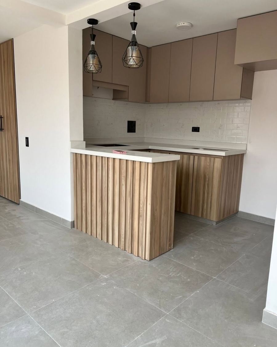 Cocina integral con barra y mesón en cuarzo
